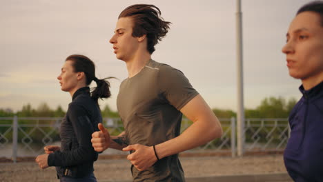 Ein-Junger-Mann-Und-Zwei-Frauen-Laufen-Gemeinsam-Im-Sommer-Beim-Training-Und-Joggen